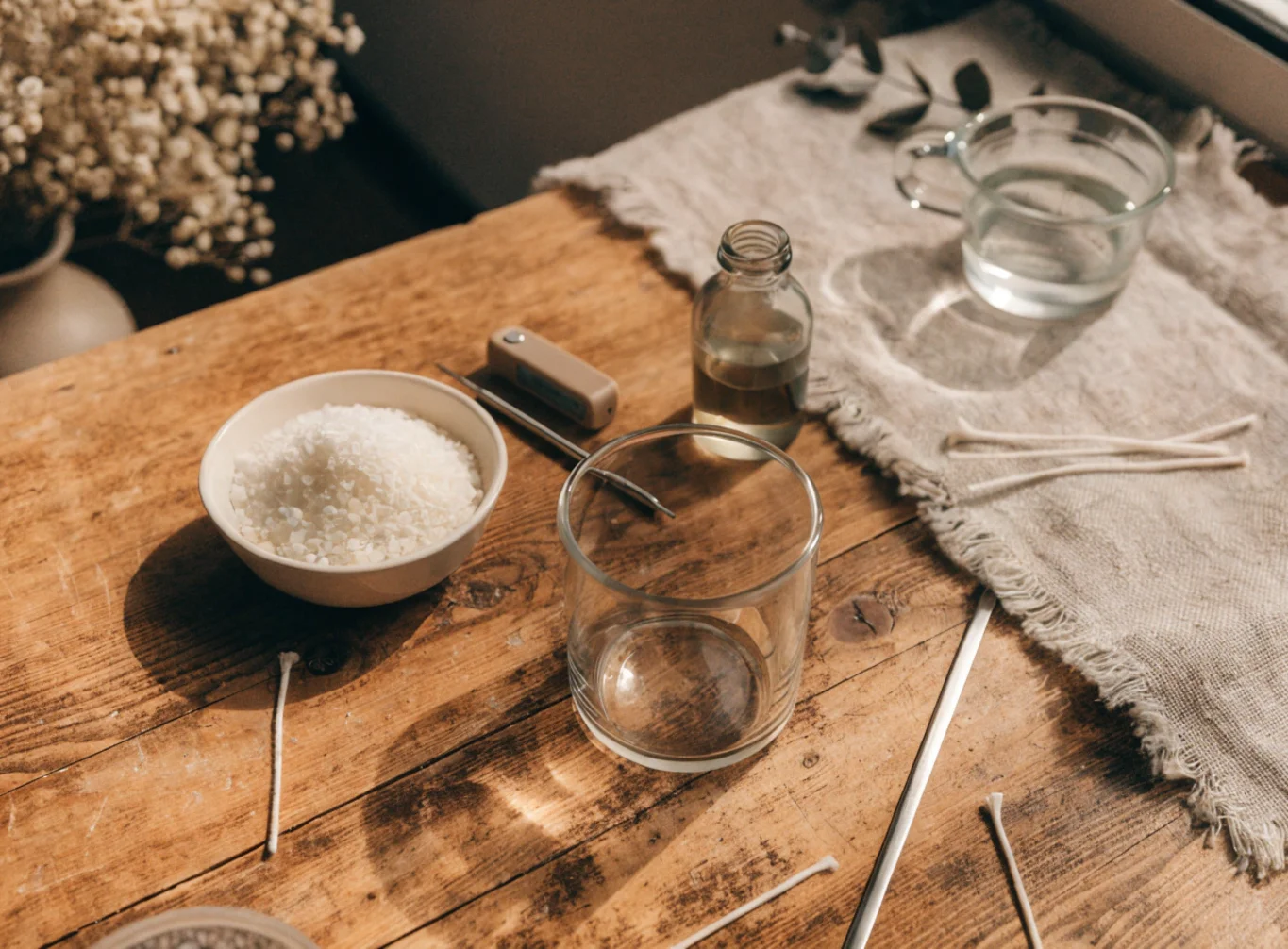 Material-Setup für eine Duftkerze im Glas: Wachs, Glas, Docht, Thermometer