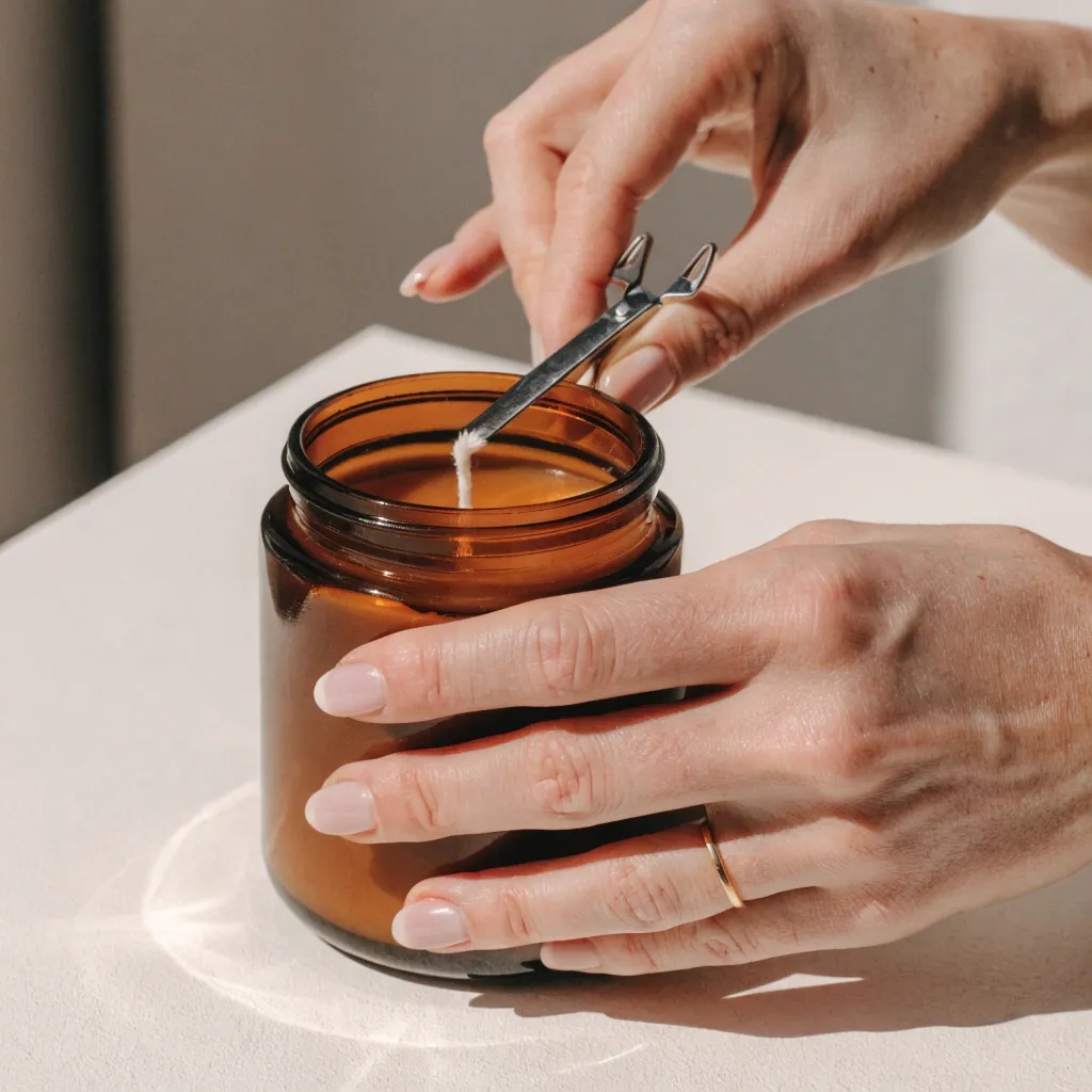 Docht an einer Kerze wird gekürzt